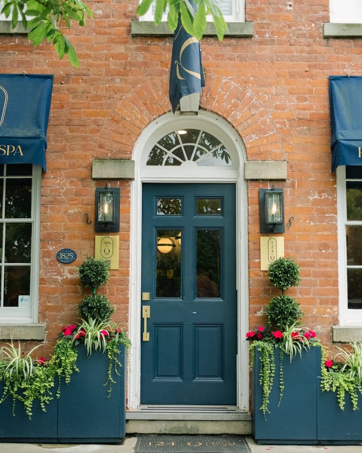 The navy front door, awnings and flower boxes of 124 on Queen Hotel & Spa