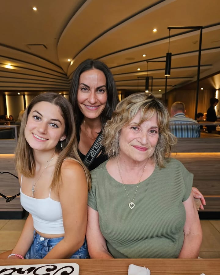 Kim Rossi, centre, and Mary Ann McIntyre, right, smiling at a restaurant table with a guest