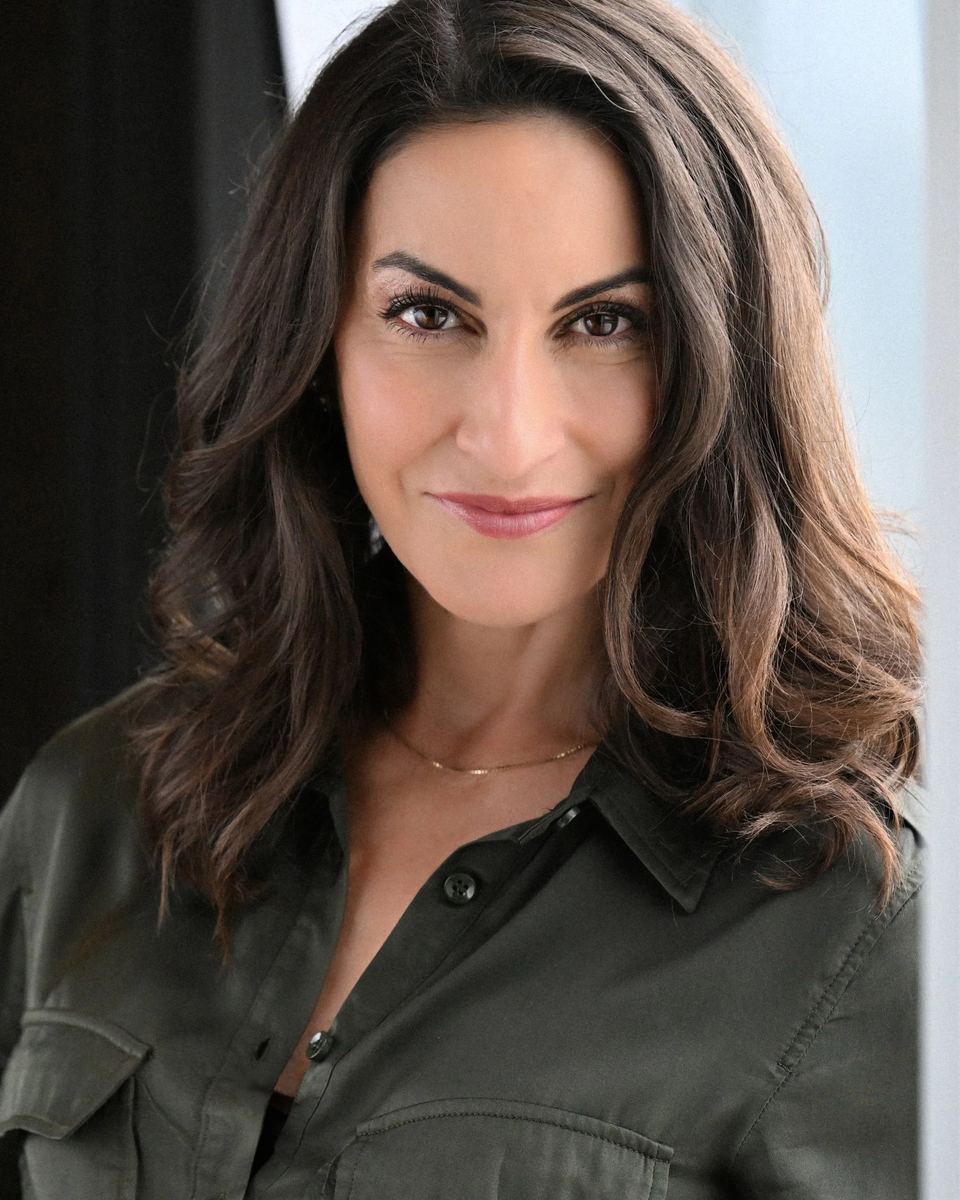 Kim Rossi, founder of Obstacles to Opportunities, smiling in a dark green shirt